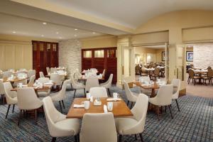 a restaurant with tables and white chairs and tablesktop at DoubleTree Boston North Shore Danvers in Danvers