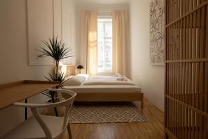 1 dormitorio con 1 cama frente a una ventana en Vibrant 107 m2 flat in the city center en Viena