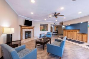a living room with blue chairs and a fireplace at Baymont by Wyndham Kirksville University Area in Kirksville