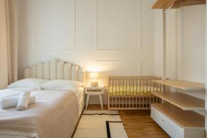 Vibrant 107 m2 flat in the city center في فيينا: غرفة نوم بسرير ابيض وسرير اطفال