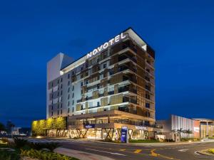 un edificio de hotel con un cartel en él en Novotel Criciuma en Criciúma