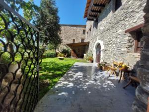 ein externes Tor zu einem Steingebäude mit einer Terrasse in der Unterkunft Casa Castan in Lirí