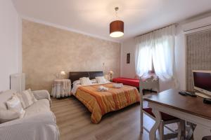 ヴァレッジョ・スル・ミンチョにあるDolce Vitaのベッドとソファ付きのホテルルーム