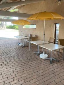 twee tafels met gele paraplu's in een gebouw bij Appartement « Athènes » à Avignon in Avignon