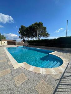 een zwembad met blauw water in een tuin bij Appartement « Athènes » à Avignon in Avignon