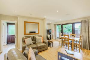 a living room with a couch and a table at Birch Lodge 23 with Hot Tub in Newton Stewart