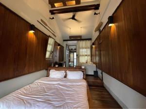 um quarto com uma cama grande e paredes de madeira em Humz Canal Stay em Nonthaburi