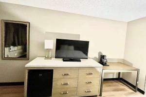 a room with a dresser with a tv on top of it at Super 8 by Wyndham Blythe in Blythe +12 photos