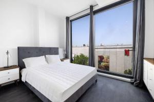 a bedroom with a large bed and a large window at The Bogart by LuxUrban, Trademark Collection by Wyndham in Brooklyn