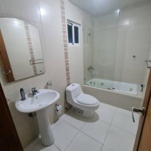 Baño blanco con lavabo y aseo en Apartamento completo en Bella vista 1 o 2 dormitorios, en Santo Domingo