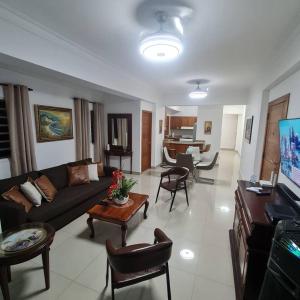 ein Wohnzimmer mit einem Sofa und einem Tisch in der Unterkunft Apartamento completo en Bella vista 1 o 2 dormitorios in Santo Domingo