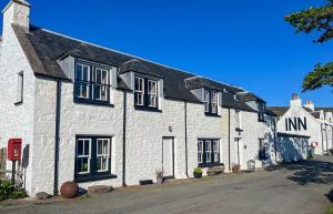 een wit bakstenen huis met zwarte ramen op een straat bij West House in Stein