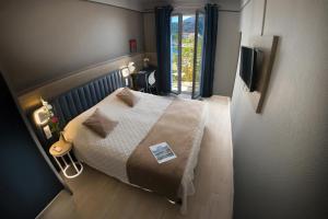 a small bedroom with a bed and a window at Hotel Le Golfe in Cassis