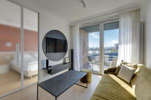 a living room with a couch and a large window at Grand Apartments Chlebova in Gdańsk