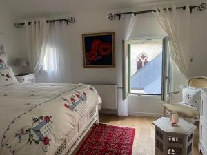 a white bedroom with a bed and a window at Place Sainte Marguerite in Provins