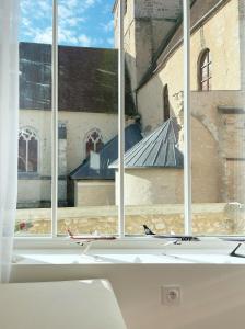 a window with a view of a building at Place Sainte Marguerite in Provins