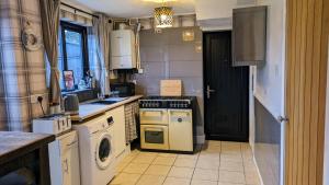 a kitchen with a stove and a dishwasher at Summerhill, Wrexham - Key Worker friendly in Wrexham