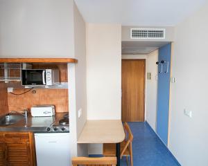 聖安東尼奧的住宿－藍色公寓酒店- 僅供成人入住，一间带桌子和微波炉的小厨房