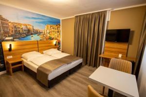 une chambre d'hôtel avec un lit et une peinture d'une ville dans l'établissement Hotel Schlangenbader Hof, à Schlangenbad