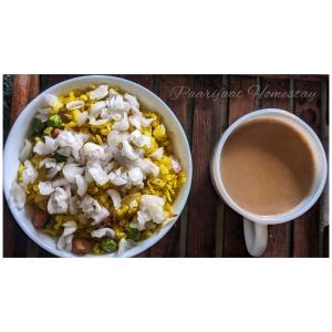 a bowl of food next to a cup of coffee at PAARIJAAT Homestay & Guesthouse in Ayodhya