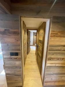 einen Flur in einem Haus mit Holzwänden in der Unterkunft Appartement centre megeve in Megève