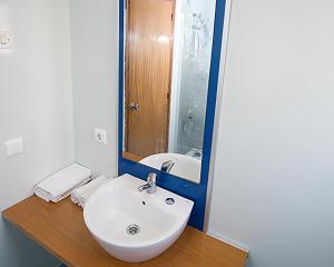 a bathroom with a white sink and a mirror at The Blue Apartments - Adults Only in San Antonio