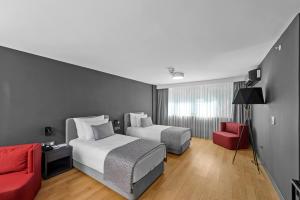 um quarto com 2 camas e um sofá vermelho em Ibos Hotels Izmir Alsancak em Alsancak