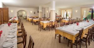 a dining room with tables and chairs with white plates at Agriturismo Scalelle in Otranto