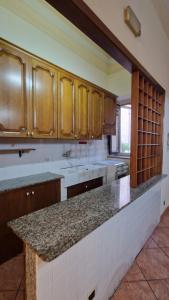 a kitchen with wooden cabinets and a granite counter top at The Crazy House in Catania