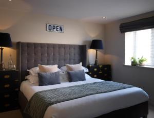 a bedroom with a large bed with blue pillows at The Harper in Langham
