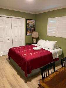 1 dormitorio con 1 cama grande con manta roja en Private LA Bedroom w Private Half-Bathroom - AC - WIFI - Private Fridge -Smart TV, en Los Ángeles