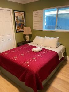 1 dormitorio con 1 cama con manta roja en Private LA Bedroom w Private Half-Bathroom - AC - WIFI - Private Fridge -Smart TV, en Los Ángeles