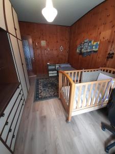 1 dormitorio con cuna en una habitación con paredes de madera en Casa vacanze Gianluca en Aosta