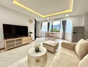 - un salon avec un canapé, une télévision et une table dans l'établissement Modern Mountain View, à Chiang Mai