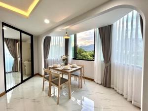 une salle à manger avec une table et une grande fenêtre dans l'établissement Modern Mountain View, à Chiang Mai