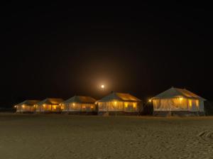 a row of tents in the desert at night at Bikaner Desert Camp and Resort in Bikaner