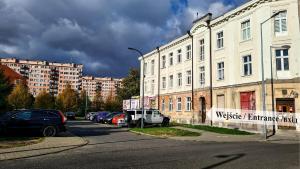 uma rua com carros estacionados em frente a um edifício em Art Apartamenty 2 em Kalisz