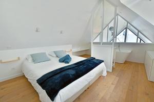 a bedroom with a large bed and a staircase at Ty Dag - Petite Terre vue mer, spa, plage à 300m in Roscoff