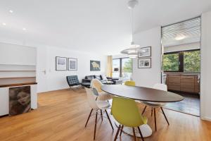 a dining room and living room with a table and chairs at EXQUIS Kunstvolles Luxusapartment I Designmöbel I Balkon I Homeoffice I Parken I Netflix in Böblingen +7 photos