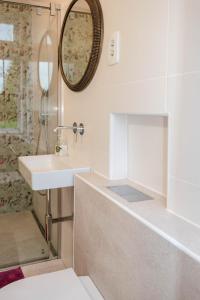 a bathroom with a sink and a tub and a mirror at Vila Jasna in Radovljica