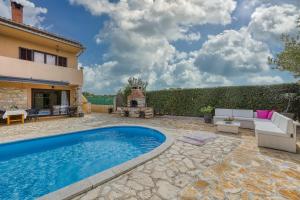 an outdoor patio with a swimming pool and a fireplace at Holiday house Marinela with Private Pool and Fenced Garden in Radetići