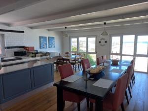 a kitchen and dining room with a table and chairs at Swept Away Guesthouse in Yzerfontein