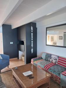 a living room with a couch and a coffee table at Swept Away Guesthouse - No-Loadshedding in Yzerfontein