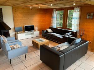 sala de estar con 2 sofás y TV en Edelweiss 4 Zi Ferienwohnung in Landhaus, en Frutigen