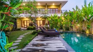 een villa met een zwembad voor een huis bij Jegeg Mas in Ubud