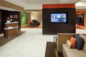 a lobby with a couch and a flat screen tv at Courtyard by Marriott Jackson Ridgeland in Jackson