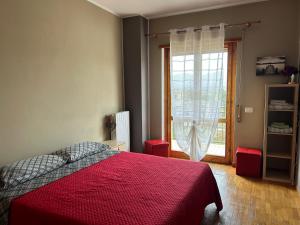 a bedroom with a red bed and a window at Dimora del CAMMINATORE in Coppito