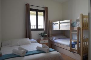 sypialnia z 2 łóżkami piętrowymi i oknem w obiekcie La Casa de la Buhardilla w mieście Fondón
