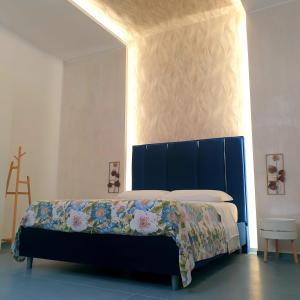 un letto con testiera blu in una stanza di Suite al Borgo ad Aversa