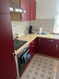 a kitchen with red cabinets and a stove top oven at Wohnung VS in Villingen-Schwenningen